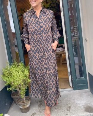 Elegant klänning med kontrasterande geometriskt tryck och lapel