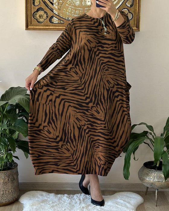 Lös modeklänning med tryck och fickor