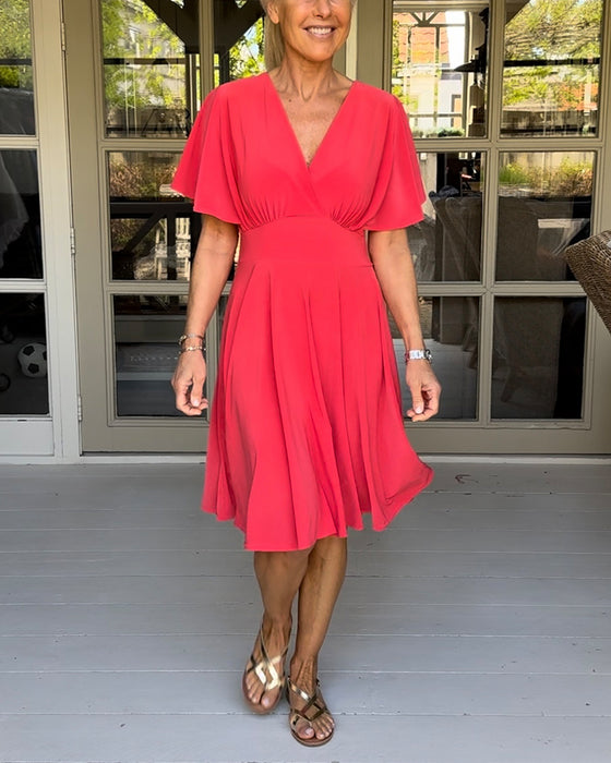 Enfärgad avslappnad klänning i midjan med V-ringning och fjärilsärm