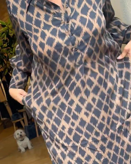 Elegant klänning med kontrasterande geometriskt tryck och lapel