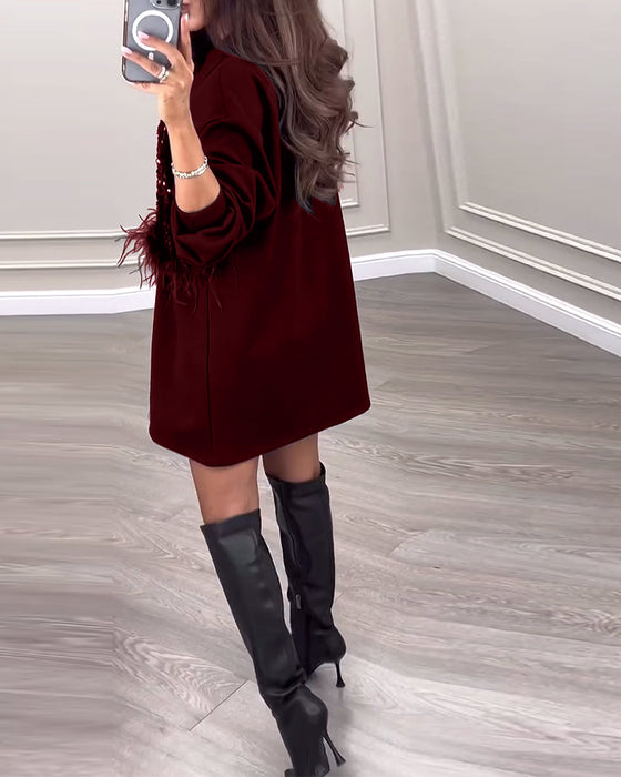 Moderiktig enfärgad klänning med paljett och fjäderpatchwork