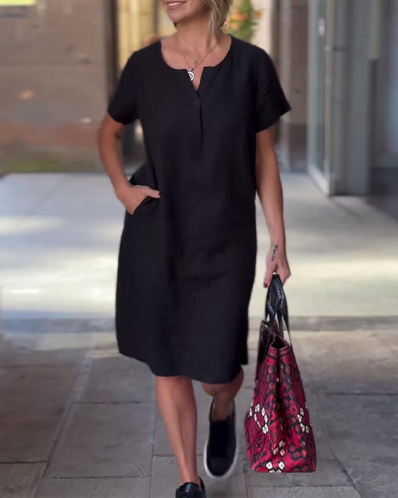 Enfärgad fickklänning med V-ringning och kort ärm