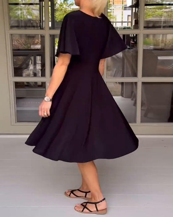 Enfärgad avslappnad klänning i midjan med V-ringning och fjärilsärm