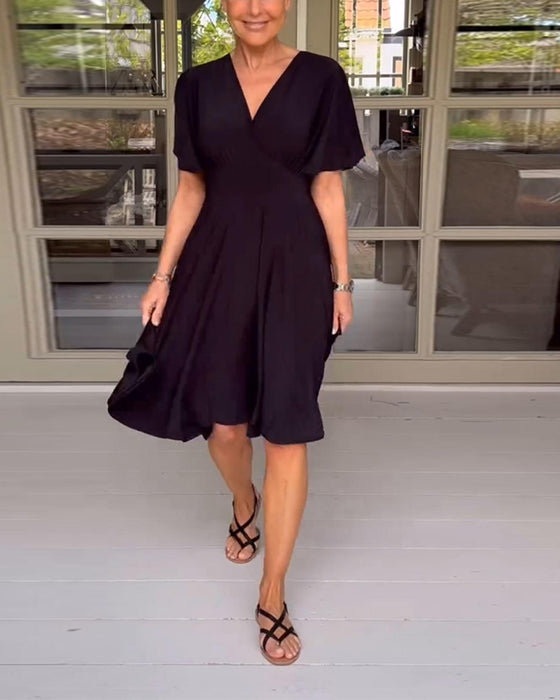 Enfärgad avslappnad klänning i midjan med V-ringning och fjärilsärm