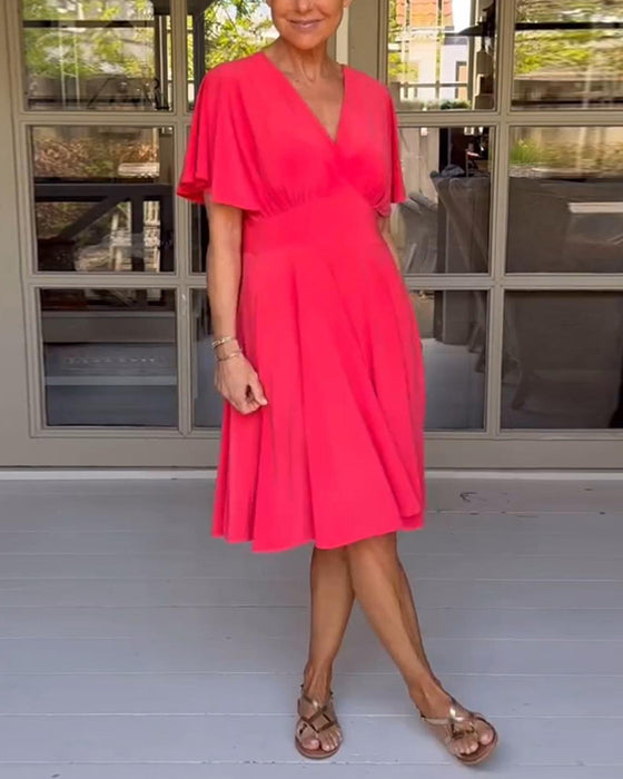 Enfärgad avslappnad klänning i midjan med V-ringning och fjärilsärm