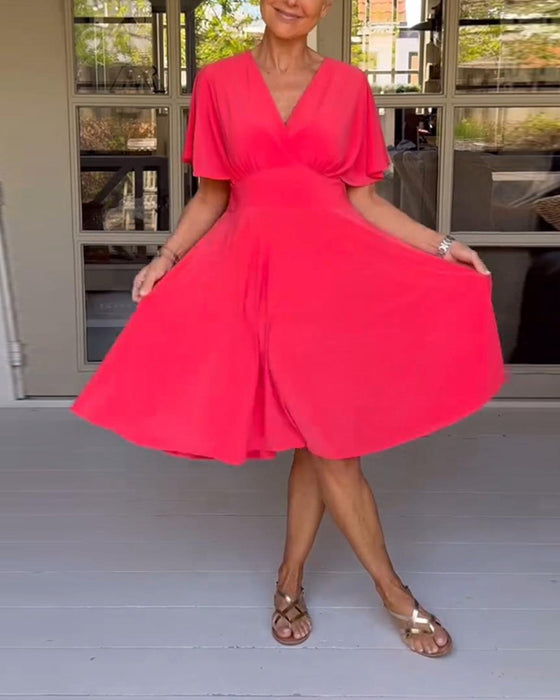 Enfärgad avslappnad klänning i midjan med V-ringning och fjärilsärm