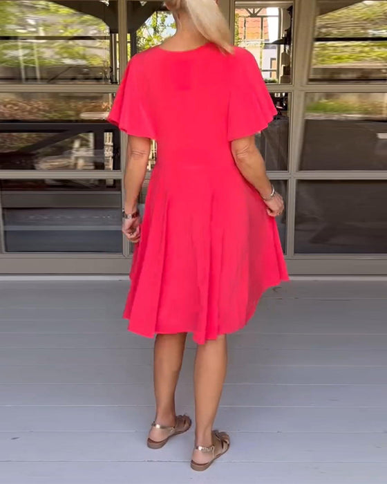 Enfärgad avslappnad klänning i midjan med V-ringning och fjärilsärm