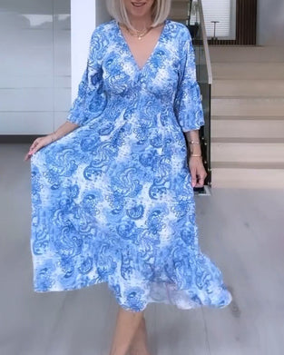 Tryckt flytande klänning med V-ringning och skärp