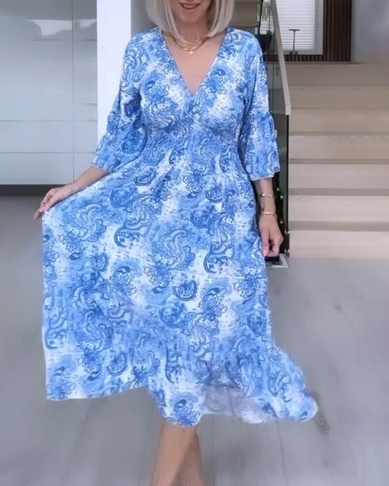 Tryckt flytande klänning med V-ringning och skärp