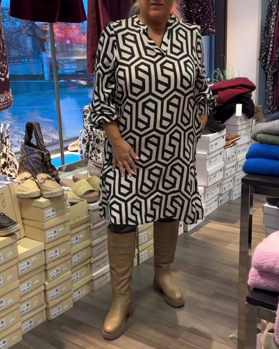 Snygg klänning med v-ringning och geometriskt mönster