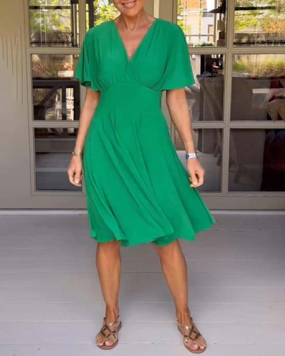 Enfärgad avslappnad klänning i midjan med V-ringning och fjärilsärm