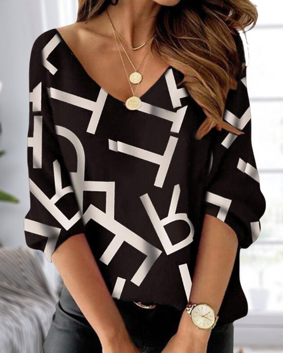 Långärmad topp med bokstavs- och fjädertryck