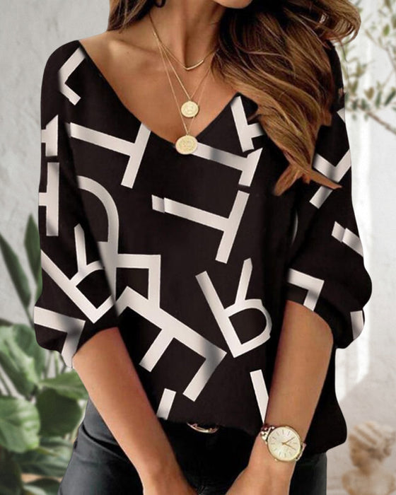 Långärmad topp med bokstavs- och fjädertryck