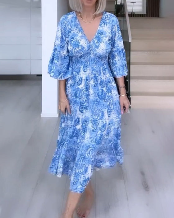 Tryckt flytande klänning med V-ringning och skärp