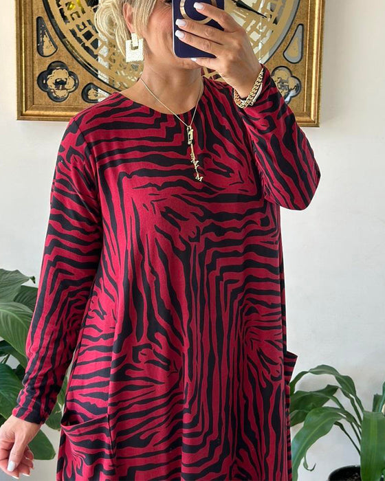 Lös modeklänning med tryck och fickor