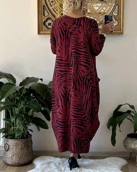 Lös modeklänning med tryck och fickor