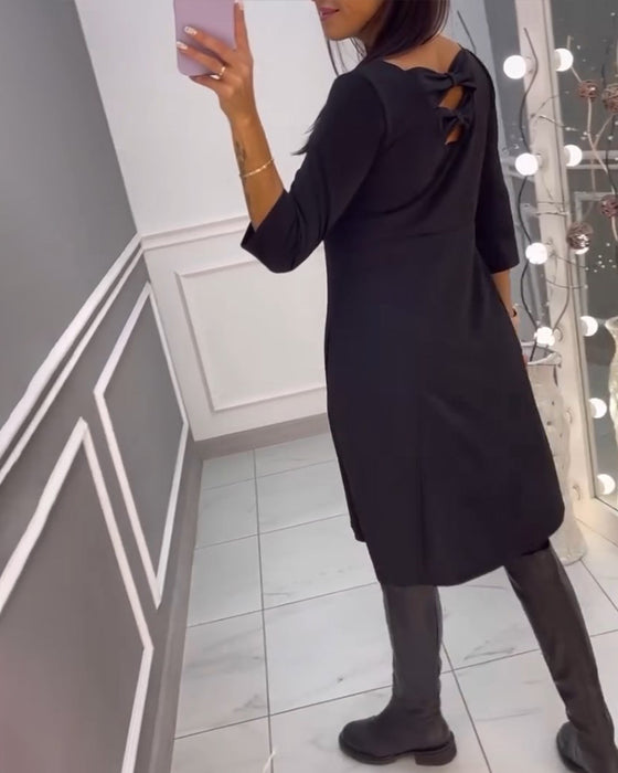 Enfärgad klänning med rosett rygg